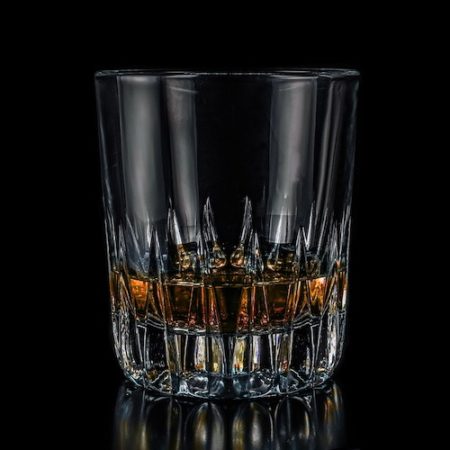 Glass of Whiskey against black background