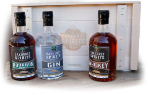 3 bottles - Bourbon, Gin, & Whiskey against Oakhurst Spirits logo crate
